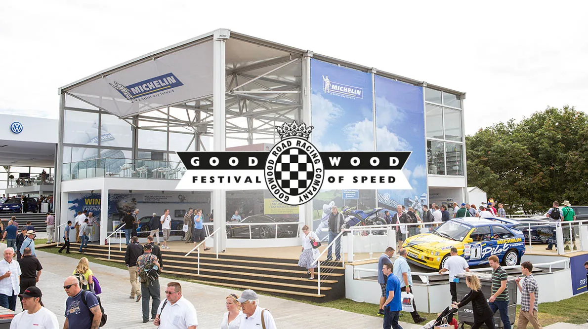 The Michelin stand at the Goodwood Festival of Speed, busy with visitors, with the festival logo overlaid.